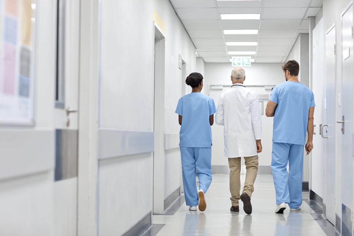 Three health care workers walking down a hallway