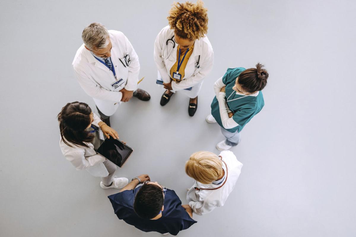 Health care workers standing in a circle while in discussion