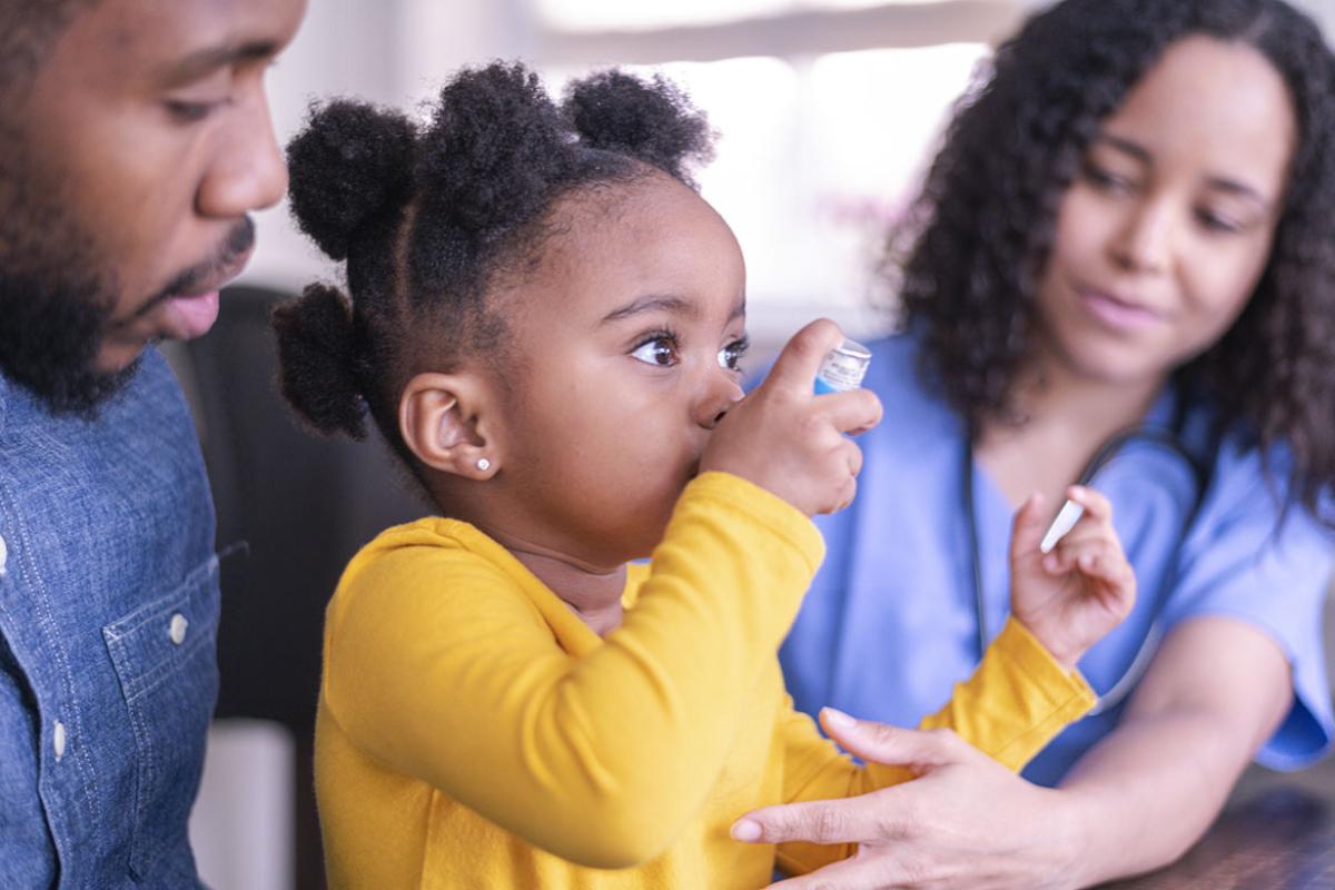 Young child uses asthma inhaler